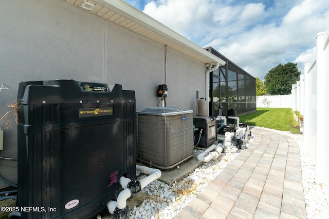 view of patio with cooling unit and glass enclosure