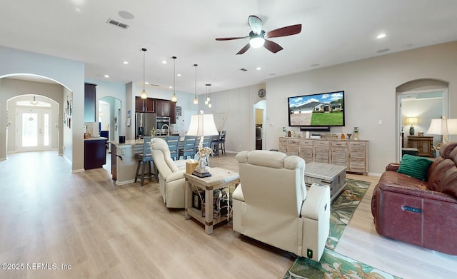 living room with sink, ceiling fan, and light hardwood / wood-style floors