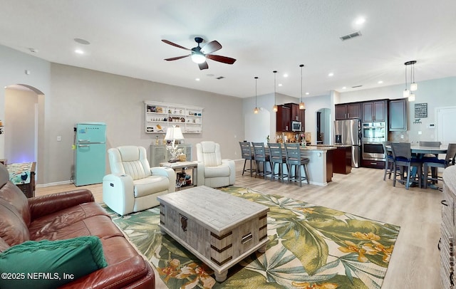 living room with ceiling fan and light wood-type flooring