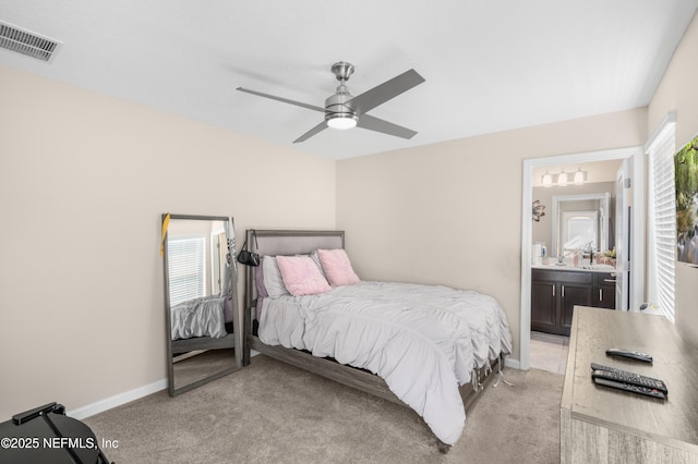 bedroom featuring ceiling fan, ensuite bathroom, light carpet, and multiple windows