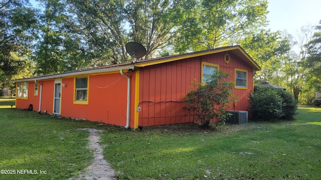 view of home's exterior with cooling unit and a lawn