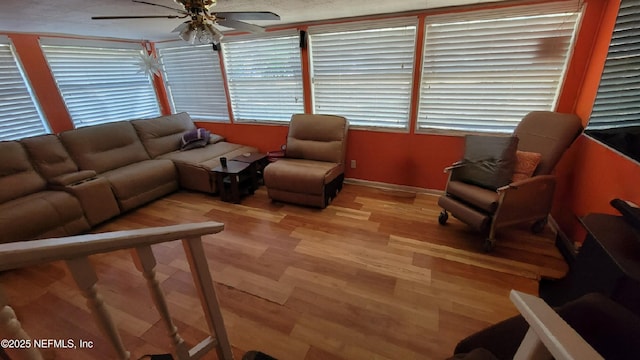 living room featuring a textured ceiling, light wood-type flooring, and ceiling fan