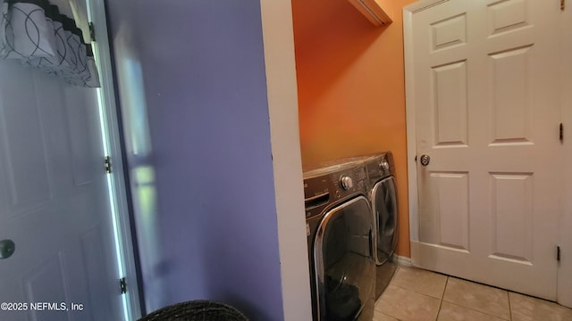 laundry area featuring washer and clothes dryer and light tile patterned floors