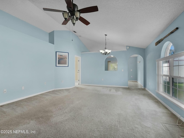 spare room featuring light carpet, a textured ceiling, ceiling fan with notable chandelier, and vaulted ceiling