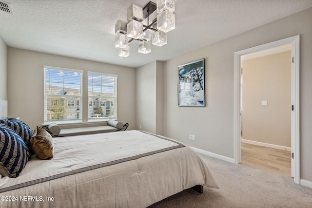 carpeted bedroom featuring a textured ceiling