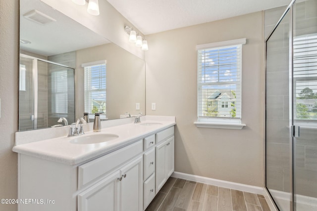 bathroom with vanity and a shower with shower door