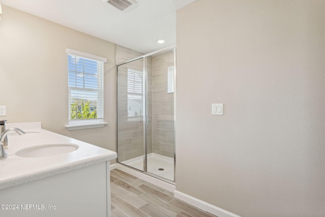 bathroom featuring vanity and a shower with shower door