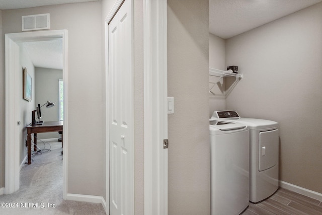 washroom featuring washing machine and dryer and light wood-type flooring