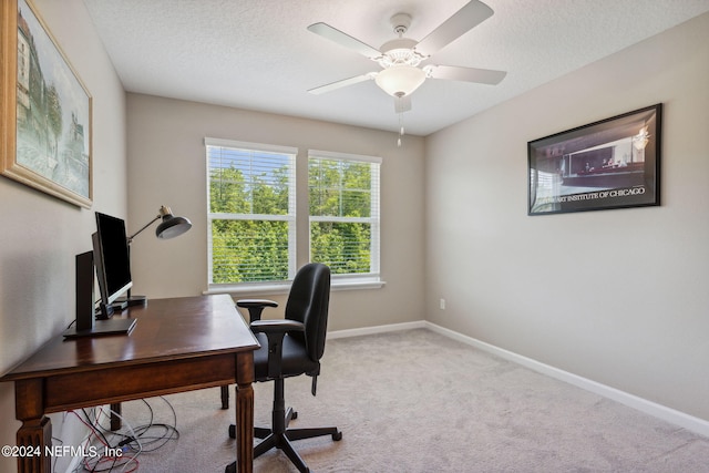 office featuring a textured ceiling, ceiling fan, and light carpet