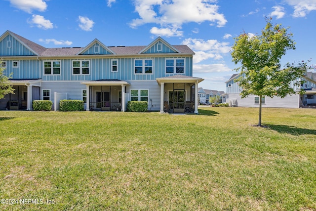 view of front of home with a sunroom and a front yard