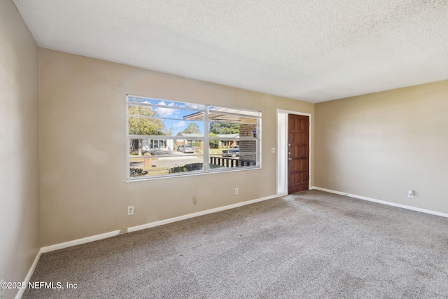 spare room featuring carpet floors and a textured ceiling