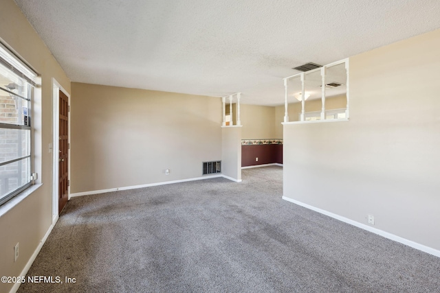 carpeted empty room with a textured ceiling