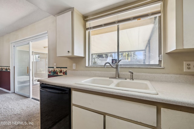 kitchen with light carpet, dishwasher, white cabinets, and sink