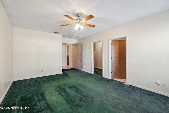 unfurnished room featuring a textured ceiling and dark colored carpet