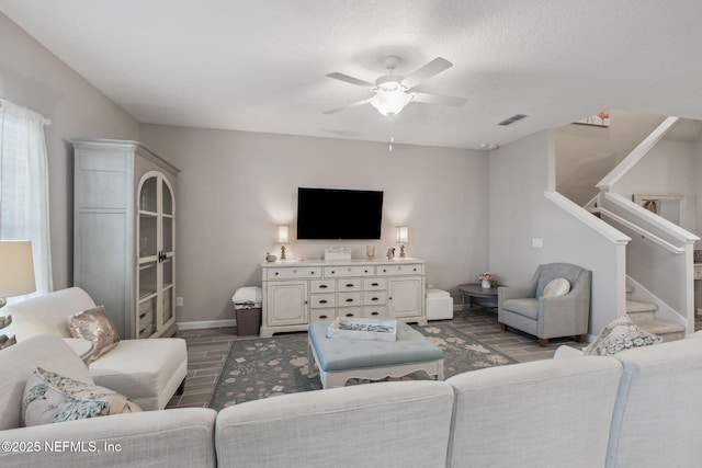 living room with ceiling fan and a textured ceiling