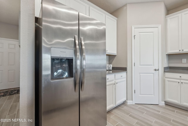 kitchen featuring stainless steel fridge with ice dispenser and white cabinetry