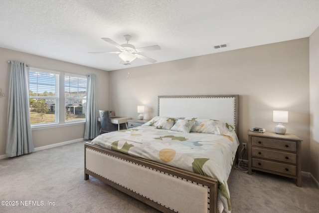 carpeted bedroom featuring a textured ceiling and ceiling fan