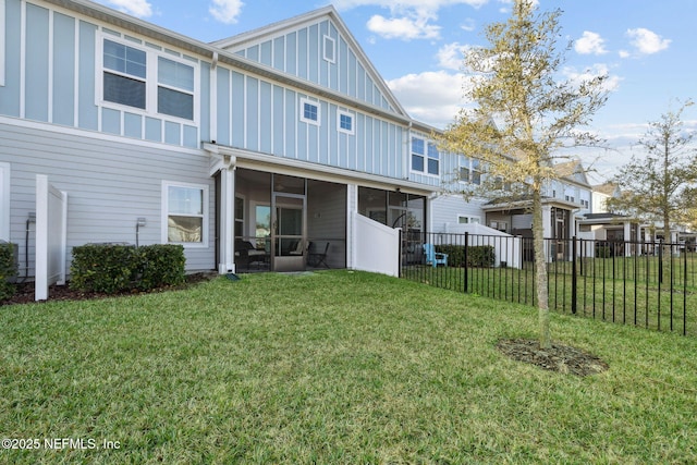 back of property with a lawn and a sunroom