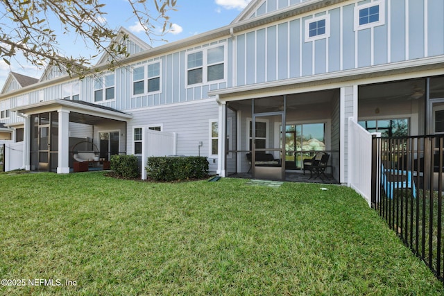 back of property featuring a sunroom and a yard