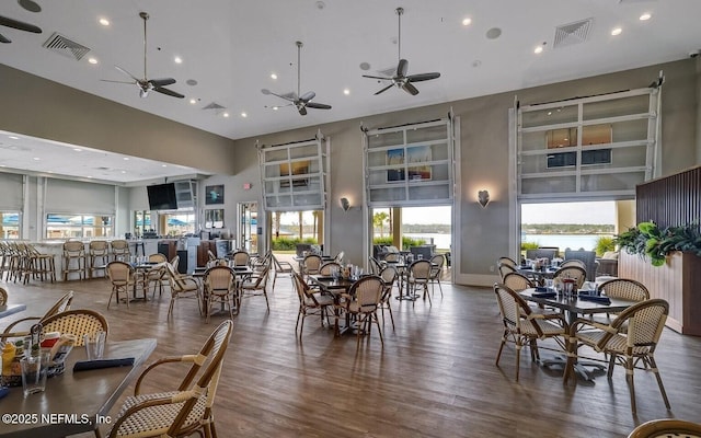 dining area with a high ceiling and dark wood-type flooring