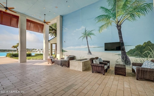 view of patio with ceiling fan and a water view