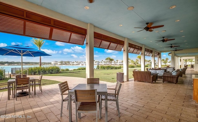 view of patio with ceiling fan and a water view