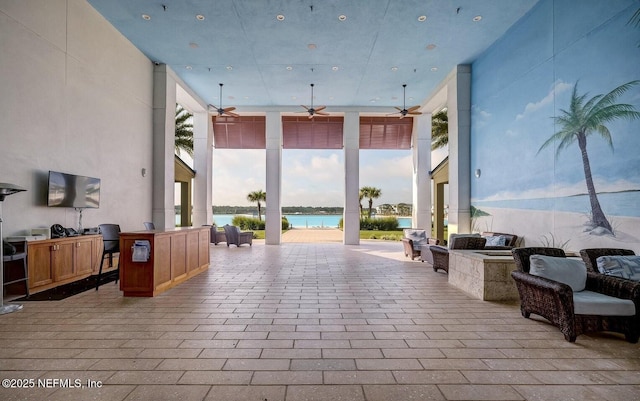 view of patio with ceiling fan and a water view