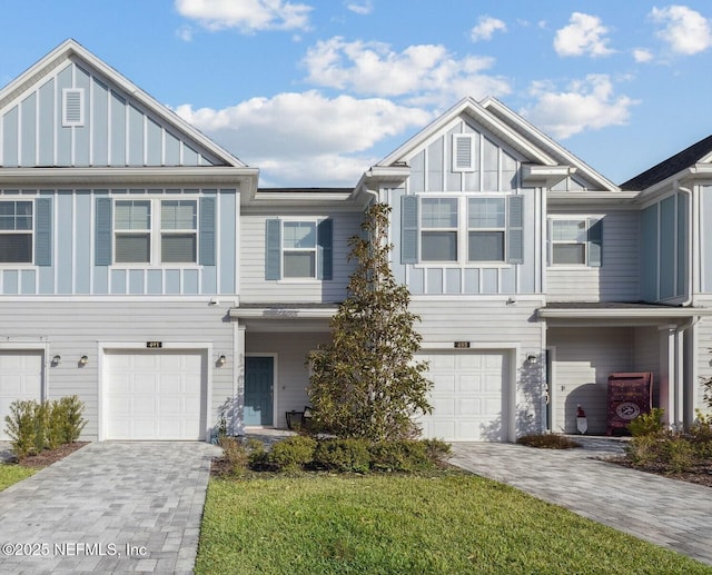 multi unit property featuring a front yard and a garage