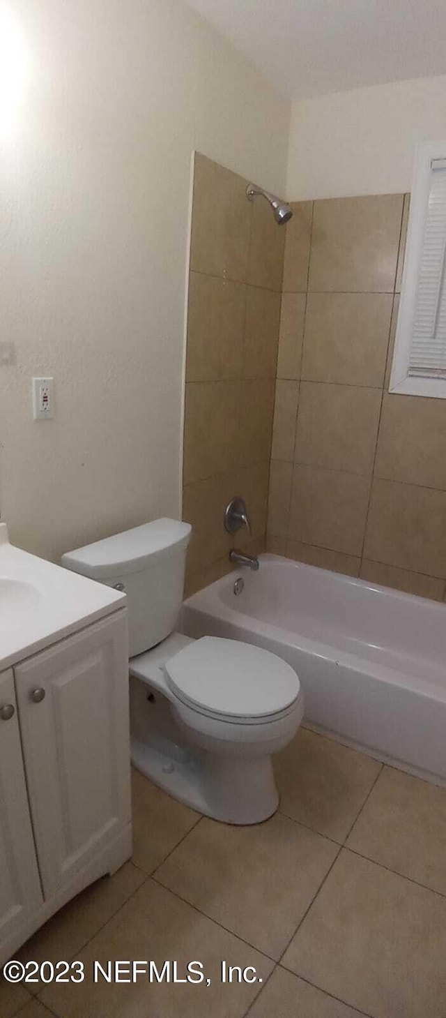 full bathroom with tile patterned flooring, vanity, tiled shower / bath combo, and toilet