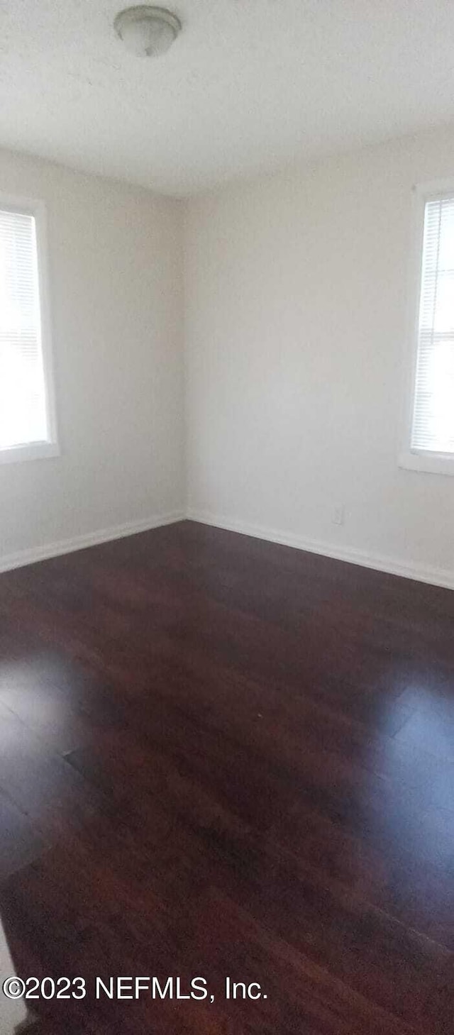 empty room with dark hardwood / wood-style flooring