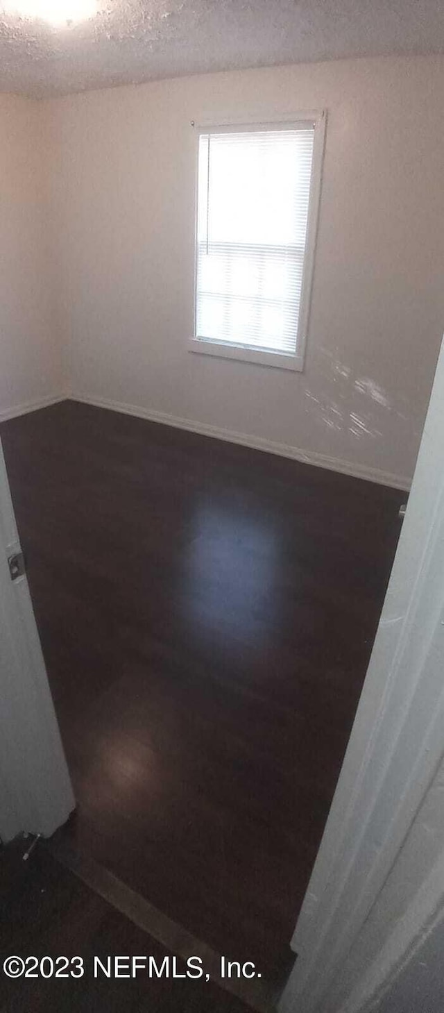 unfurnished room with a textured ceiling