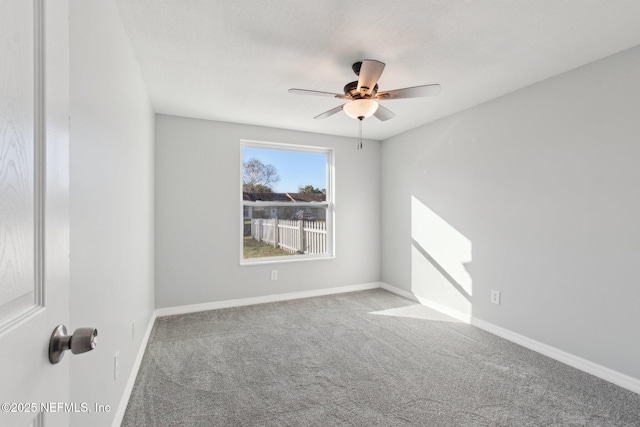 carpeted empty room featuring a ceiling fan and baseboards