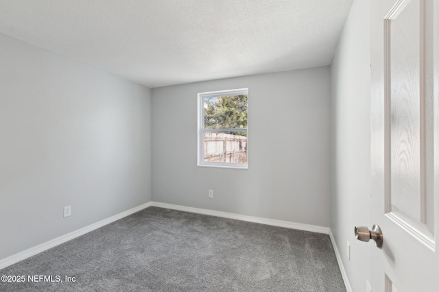 carpeted spare room featuring baseboards and a textured ceiling