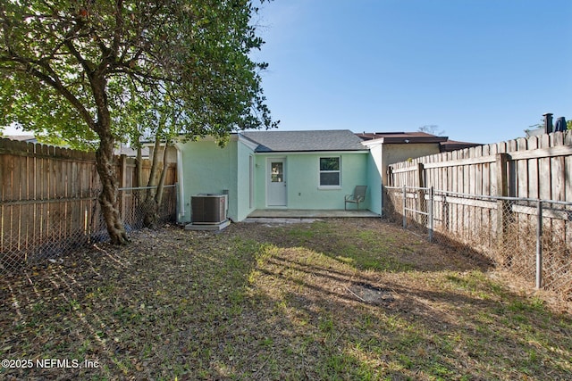 rear view of house with a fenced backyard, a patio, cooling unit, and stucco siding