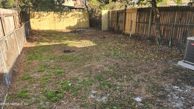 view of yard with a fenced backyard and central air condition unit