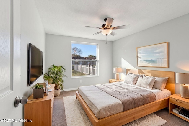 carpeted bedroom with baseboards and a ceiling fan