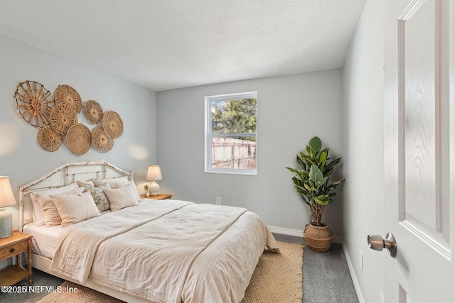 carpeted bedroom featuring a textured ceiling and baseboards