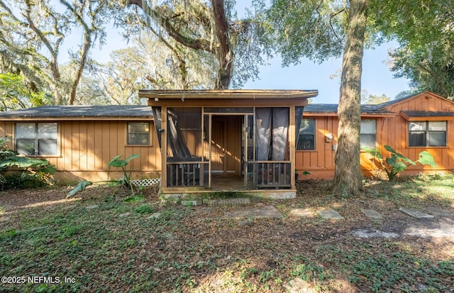 rear view of property with a sunroom