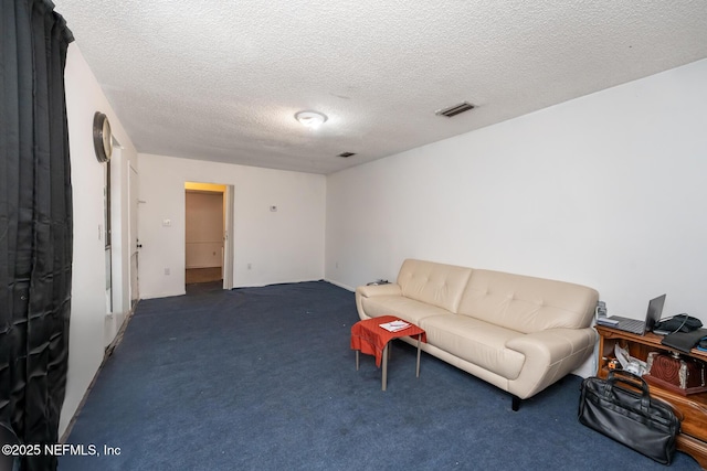 living room featuring a textured ceiling and dark colored carpet