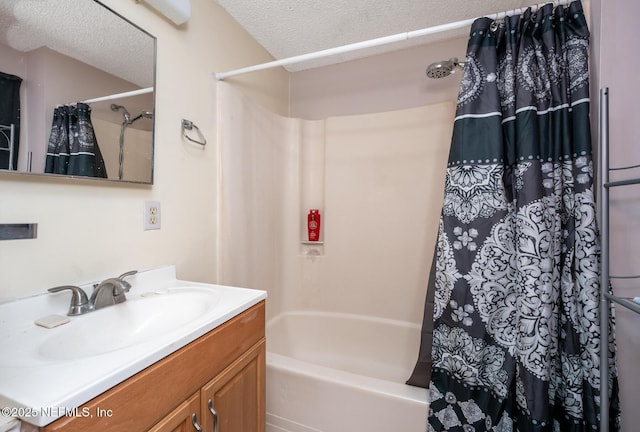 bathroom featuring shower / tub combo with curtain, vanity, and a textured ceiling