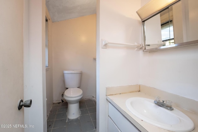 bathroom with vanity, a textured ceiling, and toilet