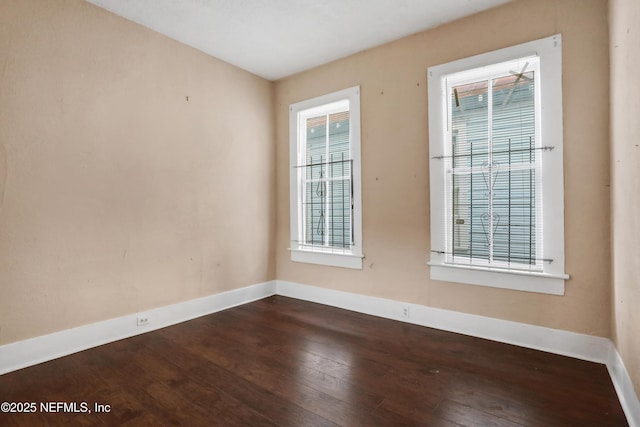 unfurnished room with dark hardwood / wood-style flooring