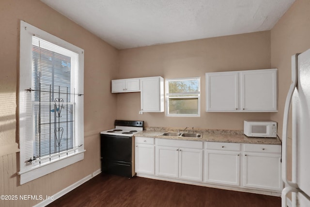 kitchen with white appliances, dark hardwood / wood-style floors, white cabinetry, and sink