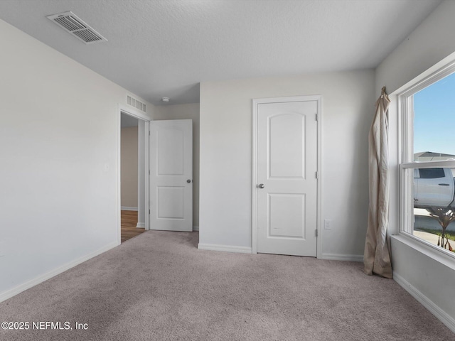 unfurnished bedroom with carpet floors and a textured ceiling