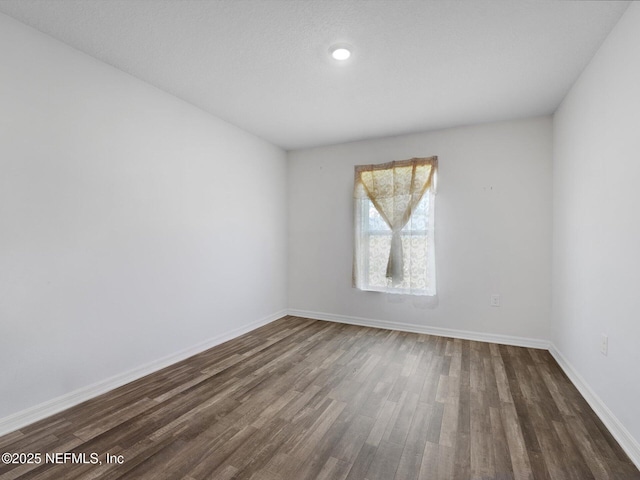 empty room featuring dark wood-type flooring