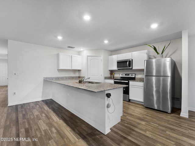 kitchen featuring sink, light stone counters, kitchen peninsula, white cabinets, and appliances with stainless steel finishes