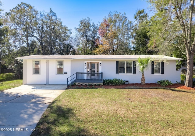 ranch-style home with a front yard and a wooden deck