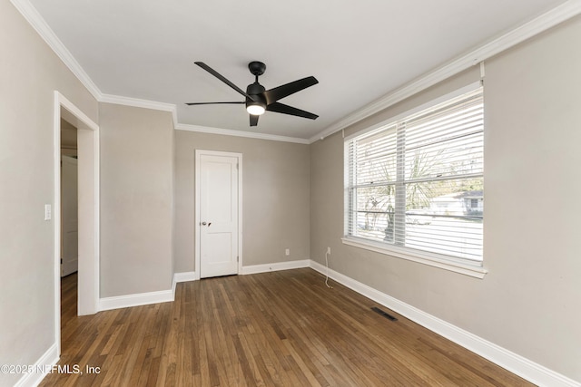 unfurnished bedroom with ceiling fan, dark wood-type flooring, and crown molding