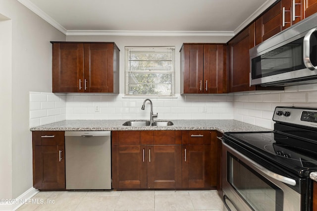 kitchen with light stone counters, appliances with stainless steel finishes, backsplash, and sink