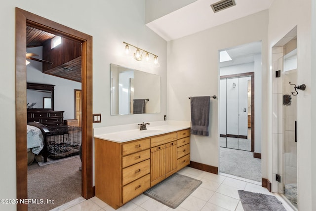 bathroom featuring tile patterned floors, vanity, and a shower with shower door